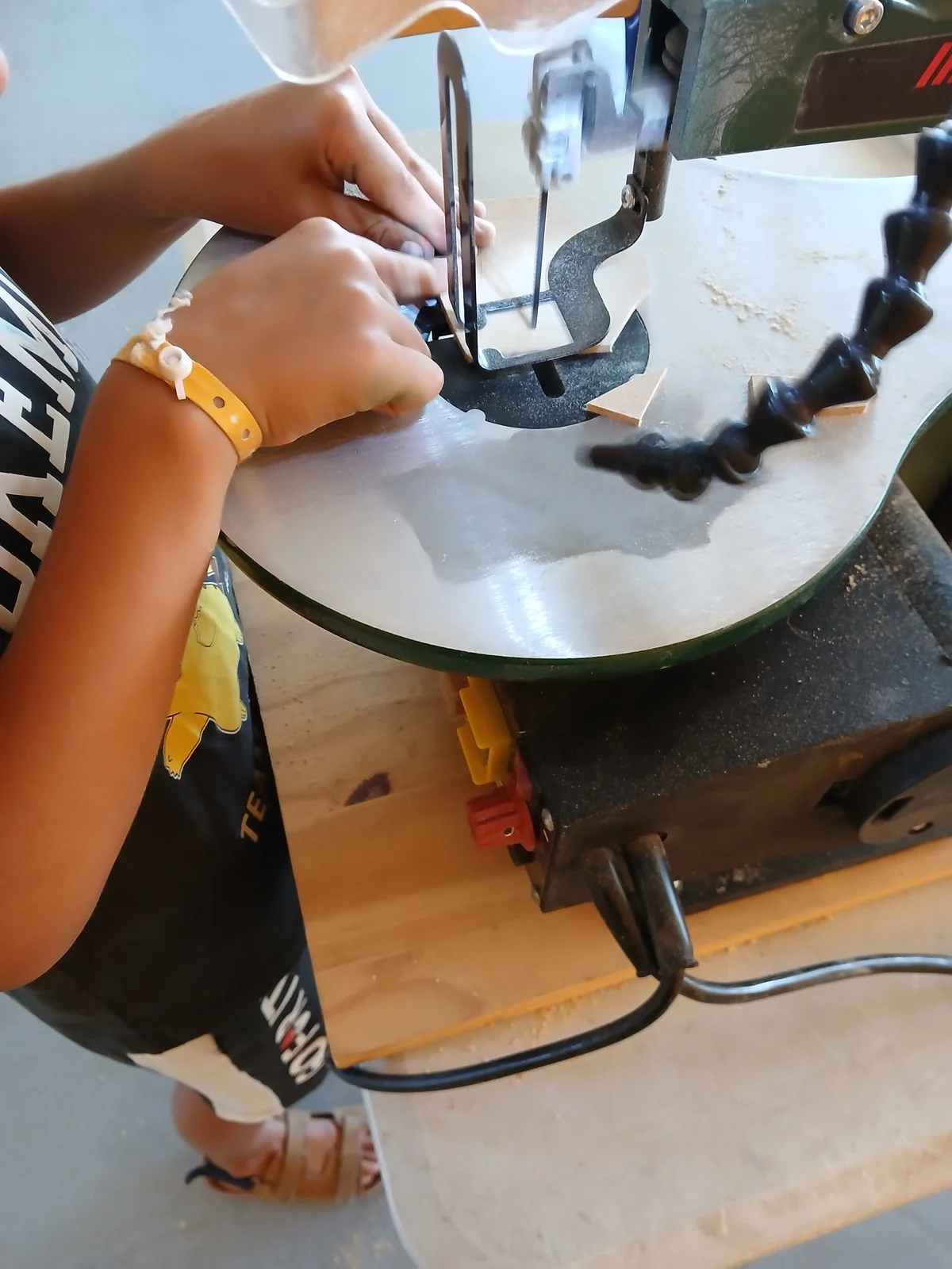 Enfant réalisant du chantournage à la scie lors d'une animation scolaire près de Libourne