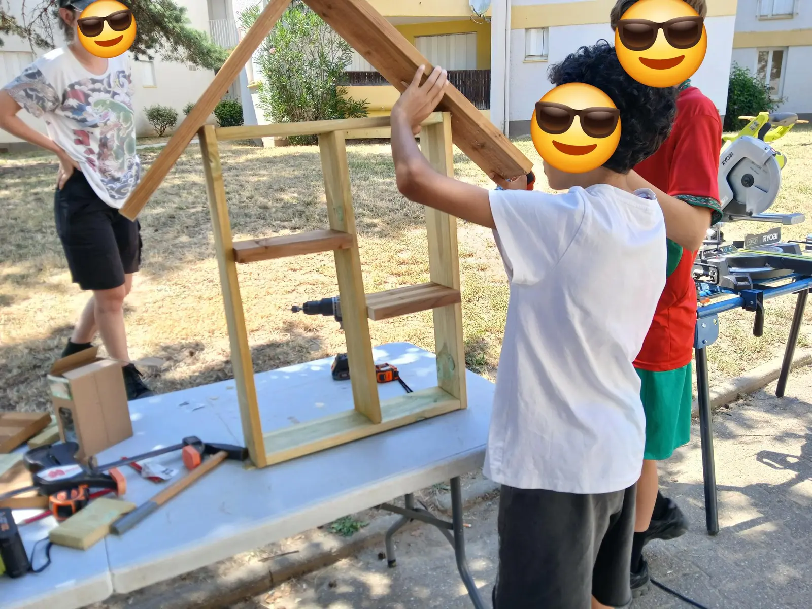 Enfants construisant une cabane en bois ensemble, apprentissage du bois de récupération