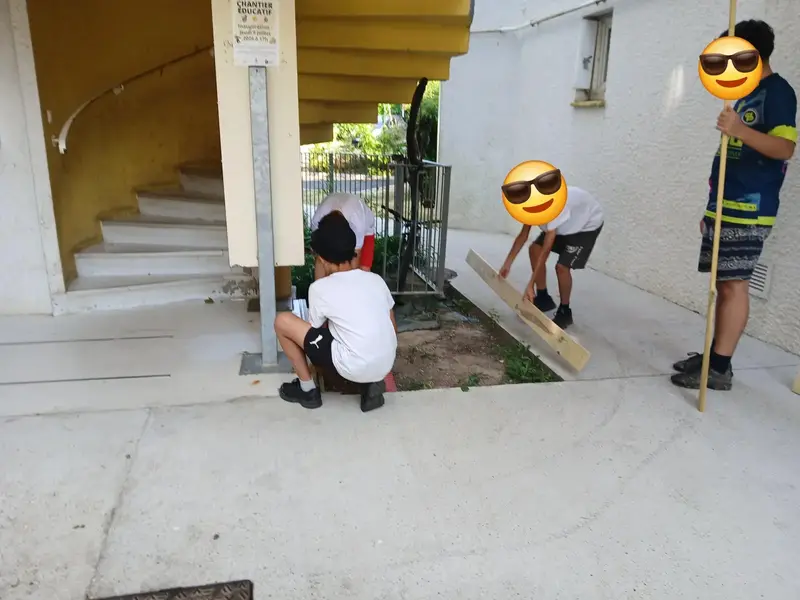 Groupe d'enfants participant à un atelier bricolage bois en extérieur