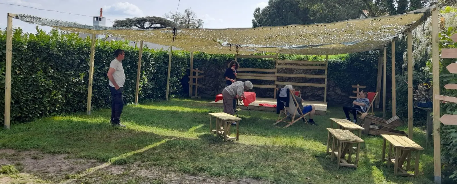 Groupe réuni sous une tonnelle lors d'un atelier bricolage bois